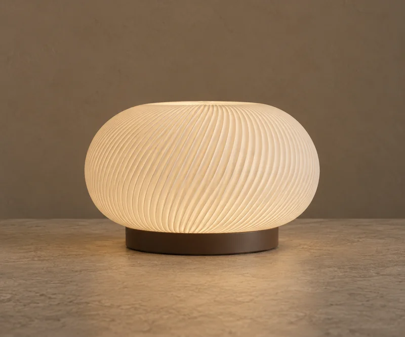 Pebble design visualization: a broad ivory oval shade with flowing ribs and a low dark base